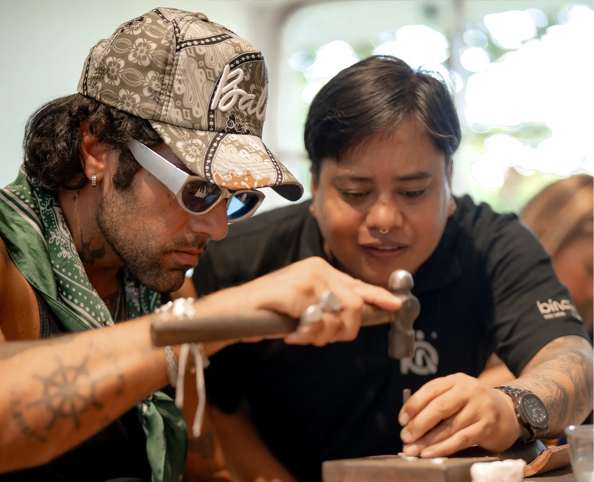 An instructor guiding a guest during a silver jewelry workshop at Bingin Silver Class Seminyak