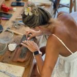 Woman shaping silver jewelry by hand during an Uluwatu silver class, focusing on traditional techniques and creative craftsmanship.