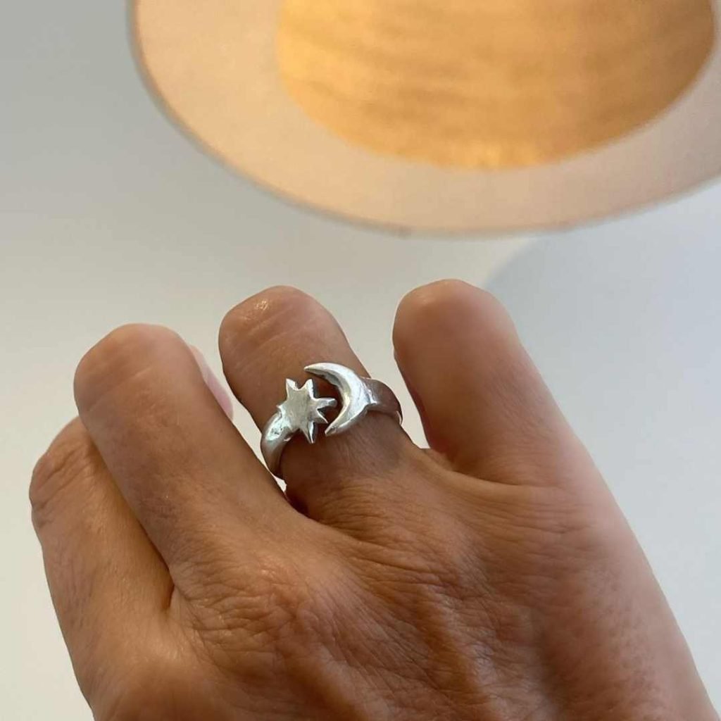 Close-up of a handmade silver ring with moon and star design, crafted at an Uluwatu silver class as a unique Balinese souvenir.