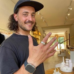 Smiling man showcasing a handmade silver ring created at an Uluwatu silver class, highlighting the personal experience of jewelry making.
