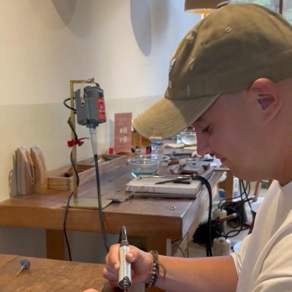a man in a hat working on a piece of wood