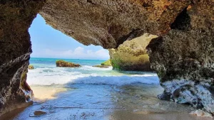 View from inside a rocky sea cave overlooking crystal-clear waves and bright blue skies near Uluwatu  a magical coastal experience that’s high on the list of Best Things to Do in Uluwatu, especially before or after joining a calming Bingin silver class session nearby.