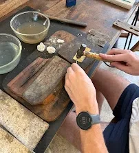 Students shaping and polishing jewelry during silver making class Ubud session.